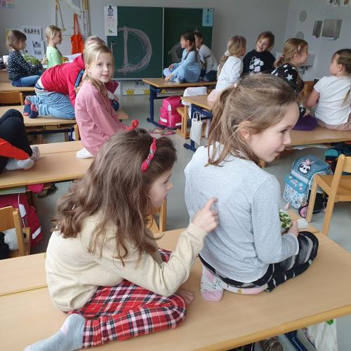 Die Kinder schreiben sich gegenseitig Buchstaben auf den Rücken